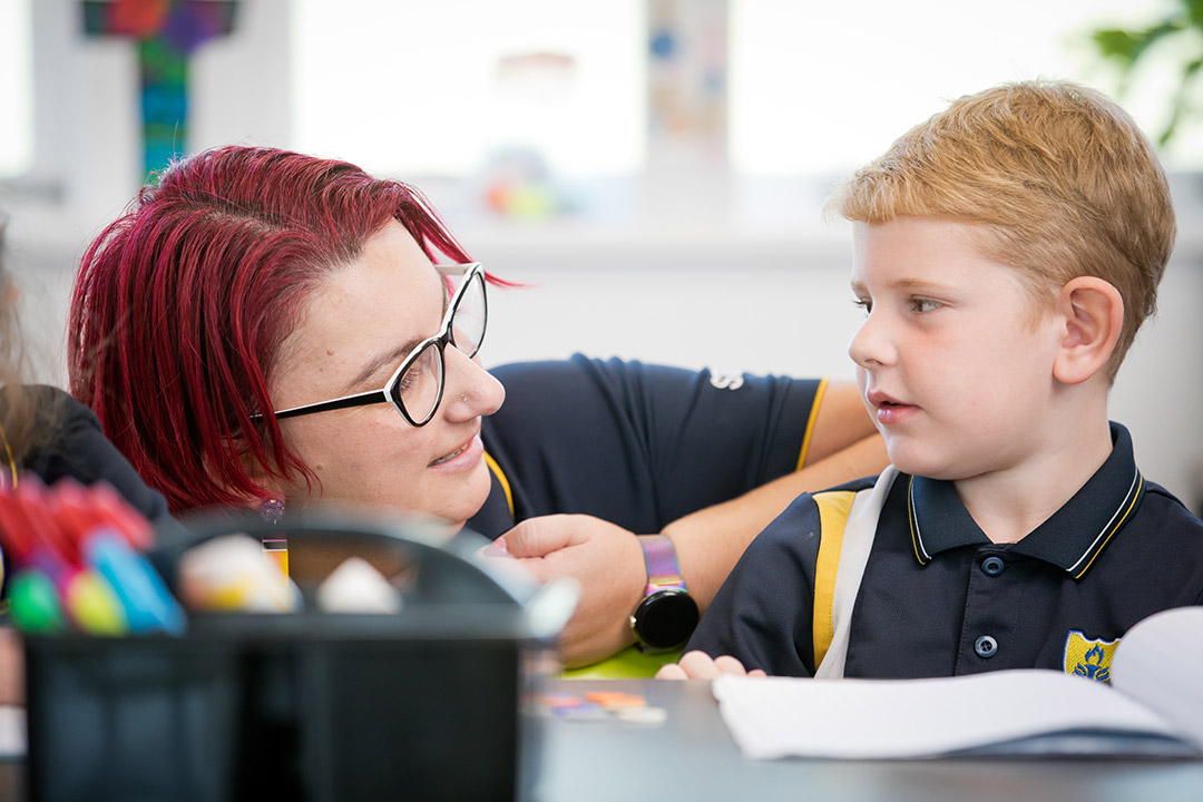 A student facing a teacher in a classroom