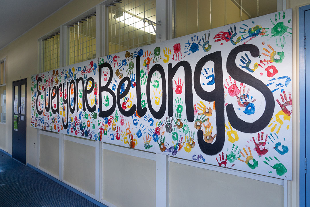 Poster of a big sign with painted handprints and the words Everyone belongs